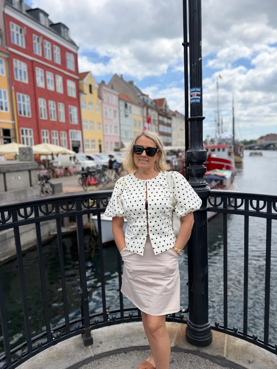 Jane Nyhavni silla peal värviliste majade taustal Kopenhaagenis