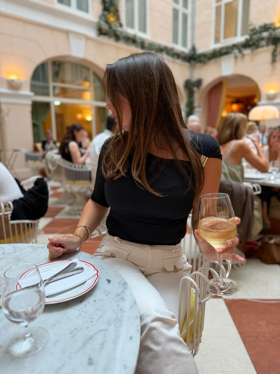 Sisehoovi restoran roosade seinte ja valgete metallmööbliga